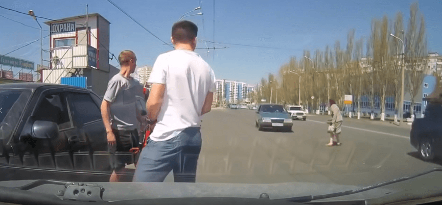 Pedestrian crossing busy city street illegally between vehicles during busy traffic