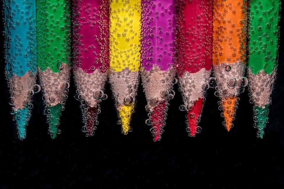 Colored pencils underwater showing how bright vehicle colors improve road safety and visibility
