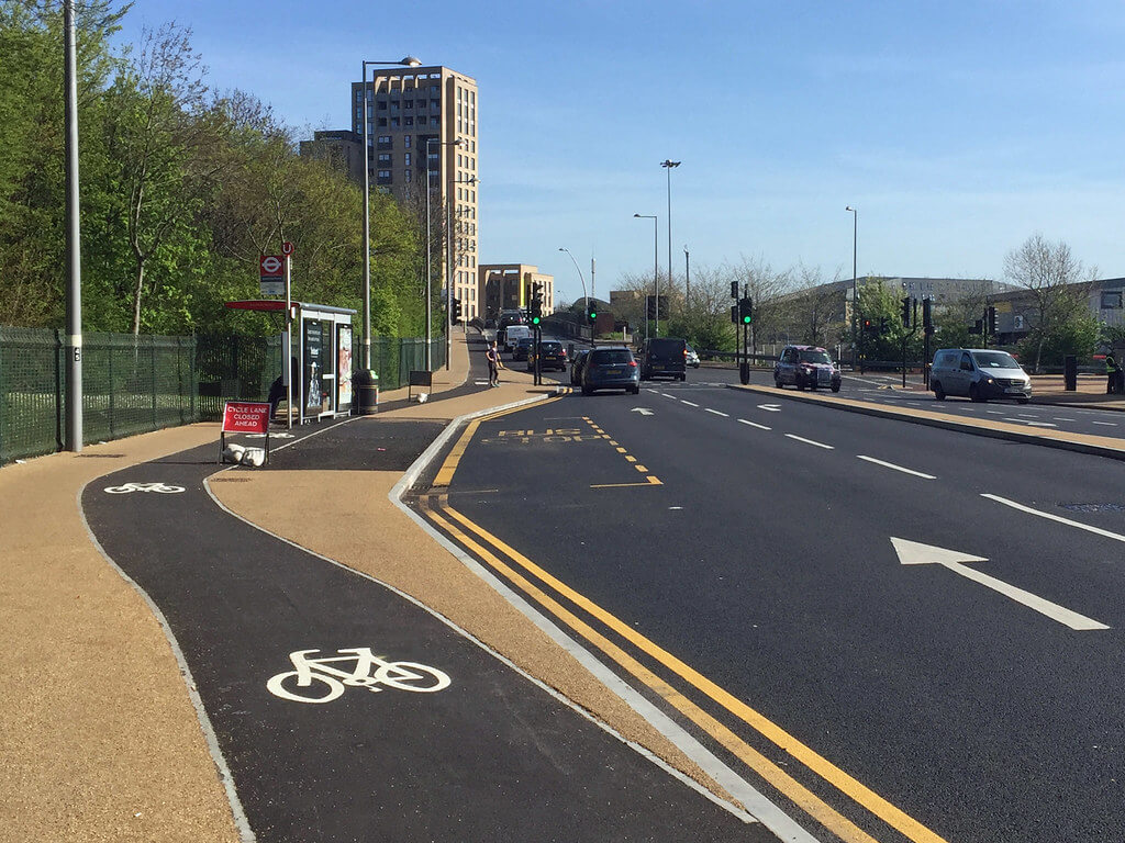 Separated cycle lane and road lanes with traffic and bus stop for urban defensive driving insight