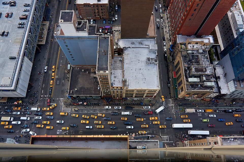 Aerial view of busy city traffic with taxis, buses, and vehicles on multi-lane urban roads