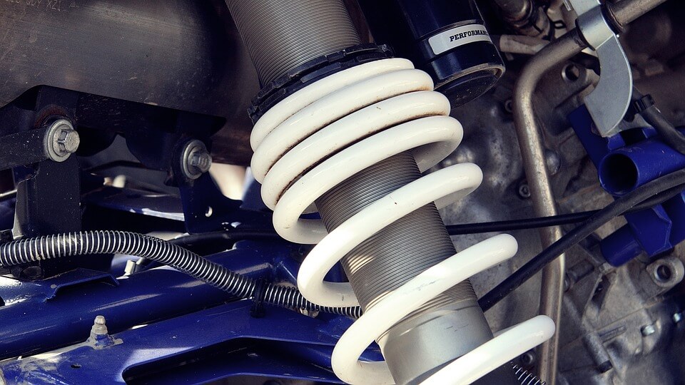 Close-up of high-performance vehicle suspension coil spring and shock absorber system